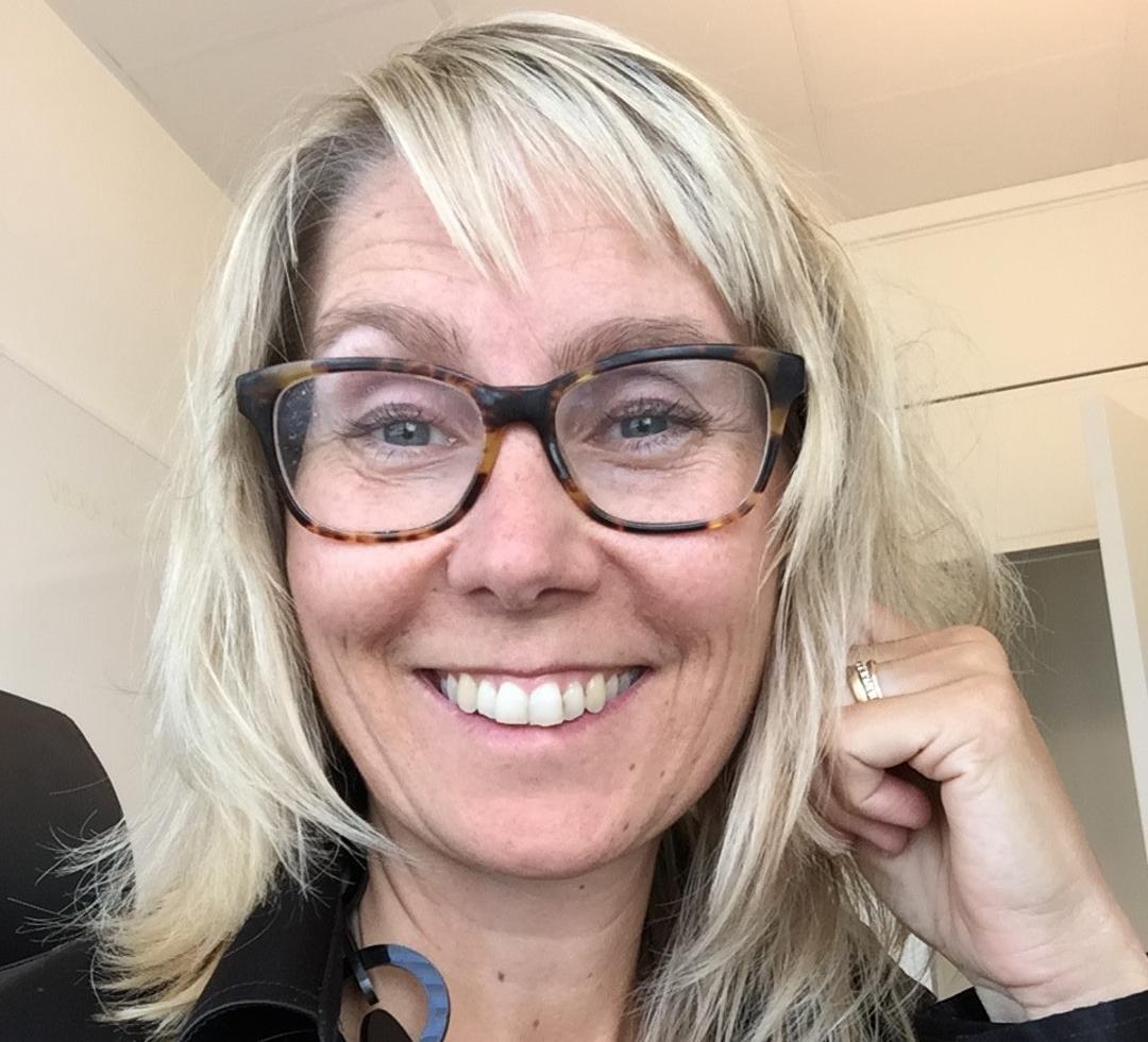 A woman looks in to the camera and smiles