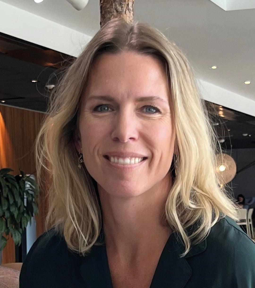 a woman smiling and looking into the camera