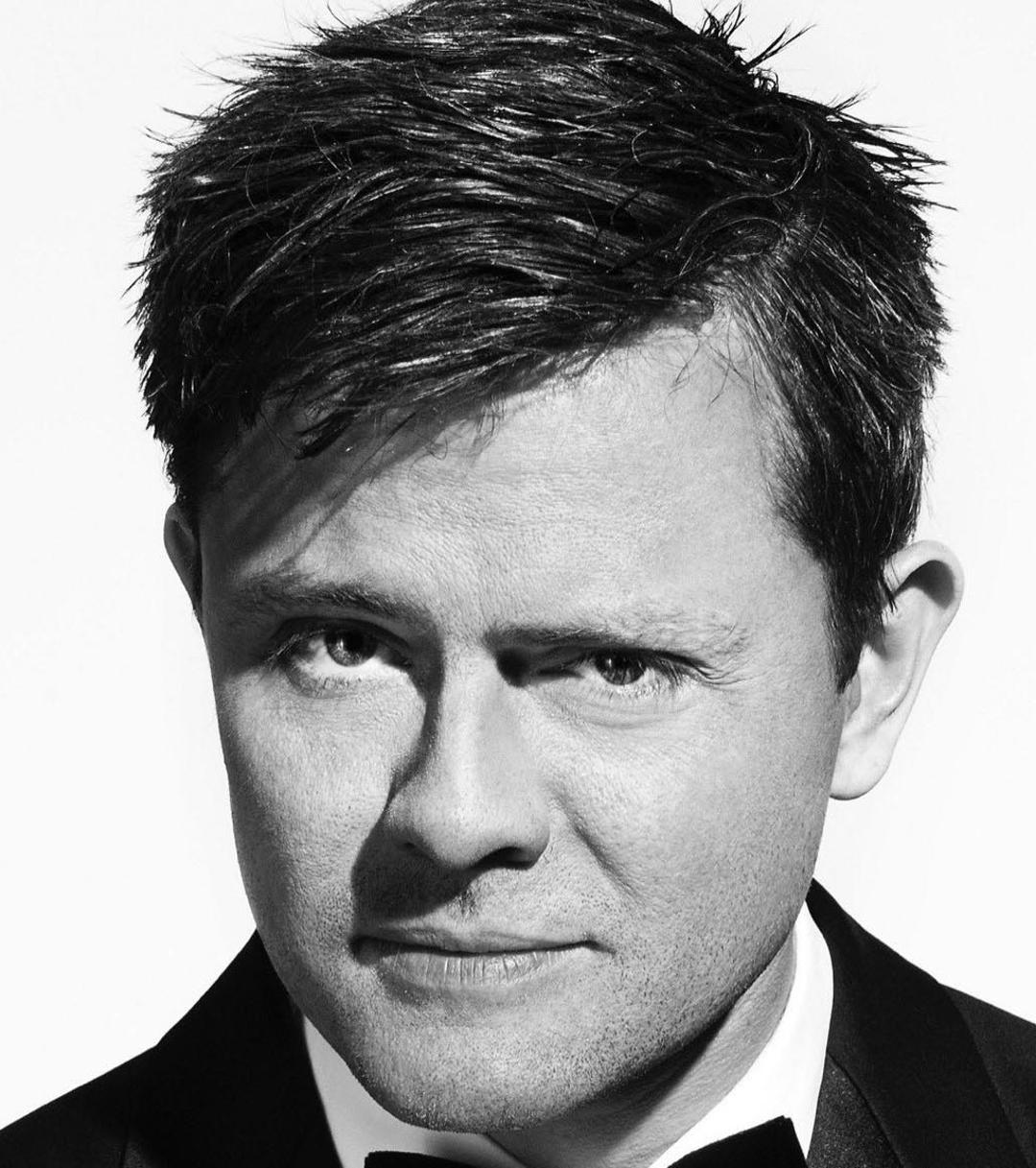 a man smiling and looking into the camera