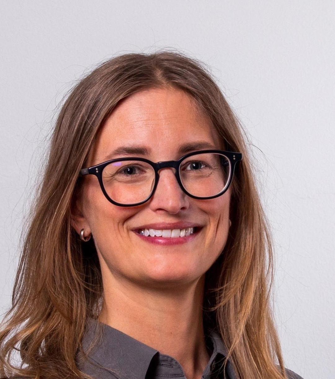 a woman smiling and looking into the camera