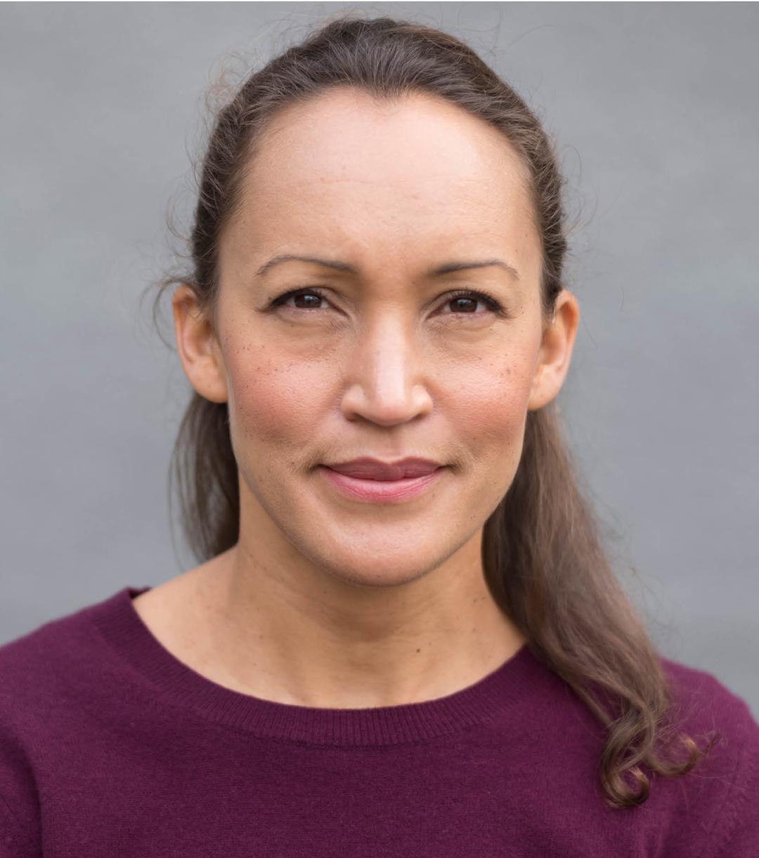 a woman smiling and looking into the camera