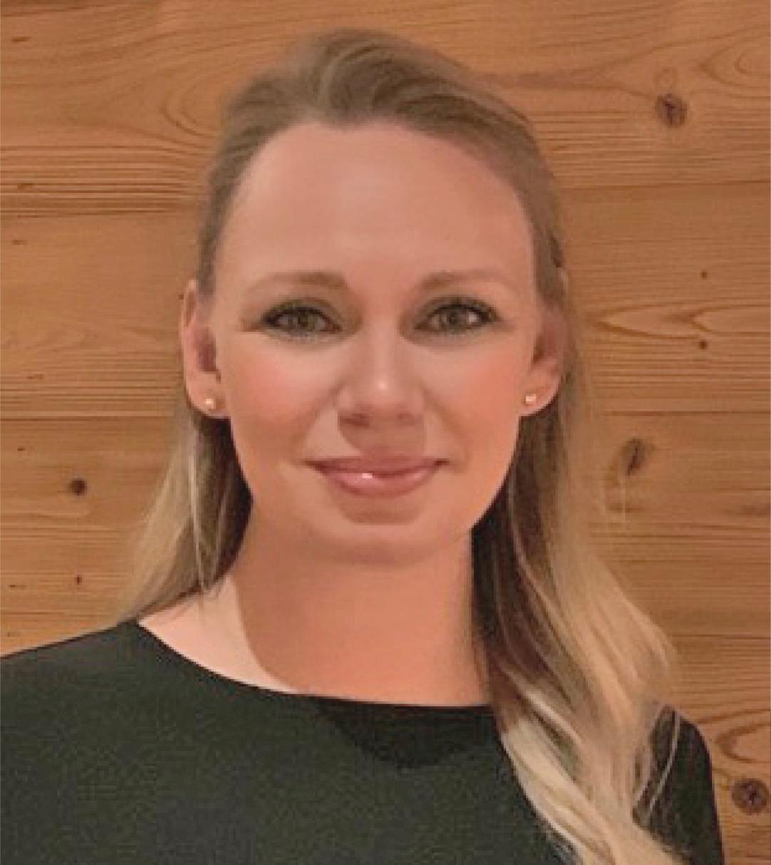 a woman smiling and looking into the camera