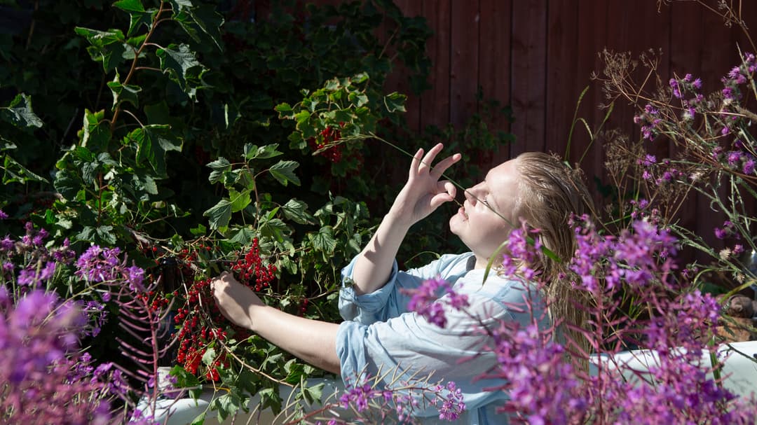 Kvinna bland lilafärgade blommor