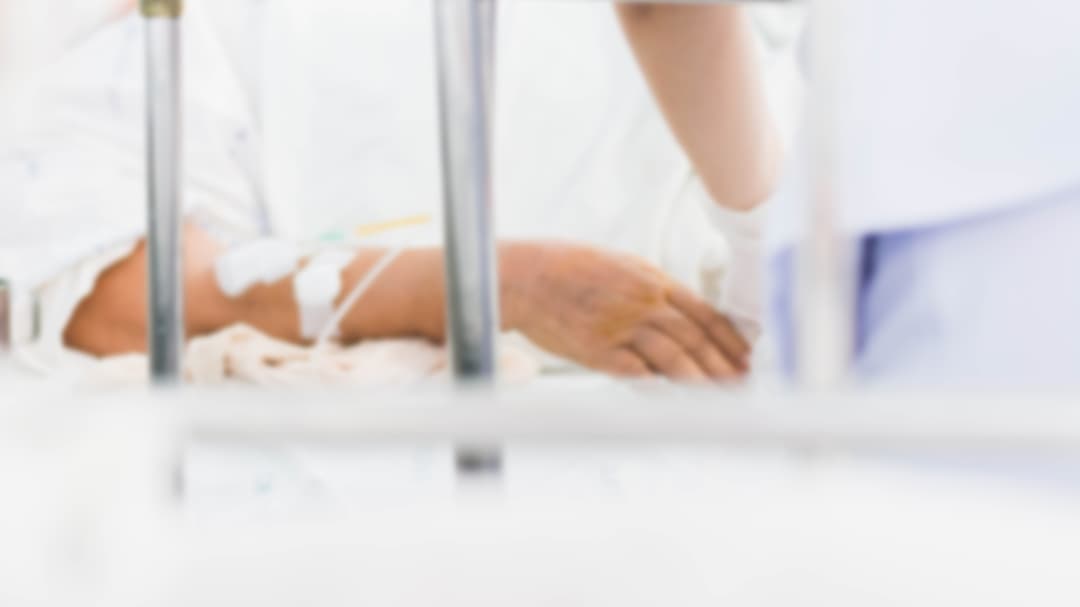 blurry photo of patient on bed with nurse take care 