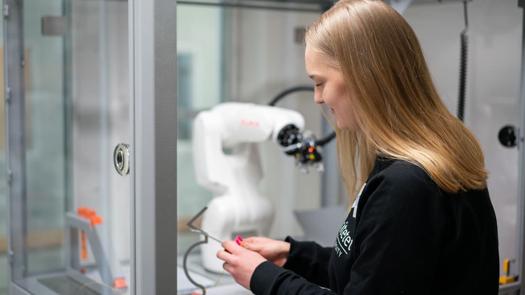 Kvinna som arbetar med en robotarm