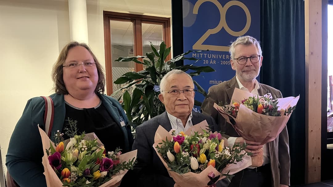  Three people each with a large bouquet of flowers stand next to each other.