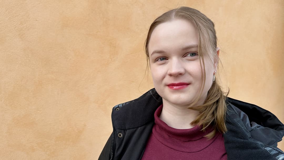 Ung tjej står framför en gul vägg