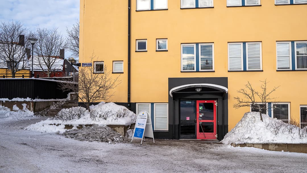 En vit byggnad, en byggnad i glas och en gul byggnad. 