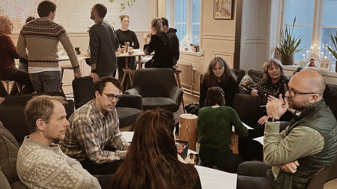 Ett tiotal kollegor sitter och pratar med varandra i ett informellt konferensrum