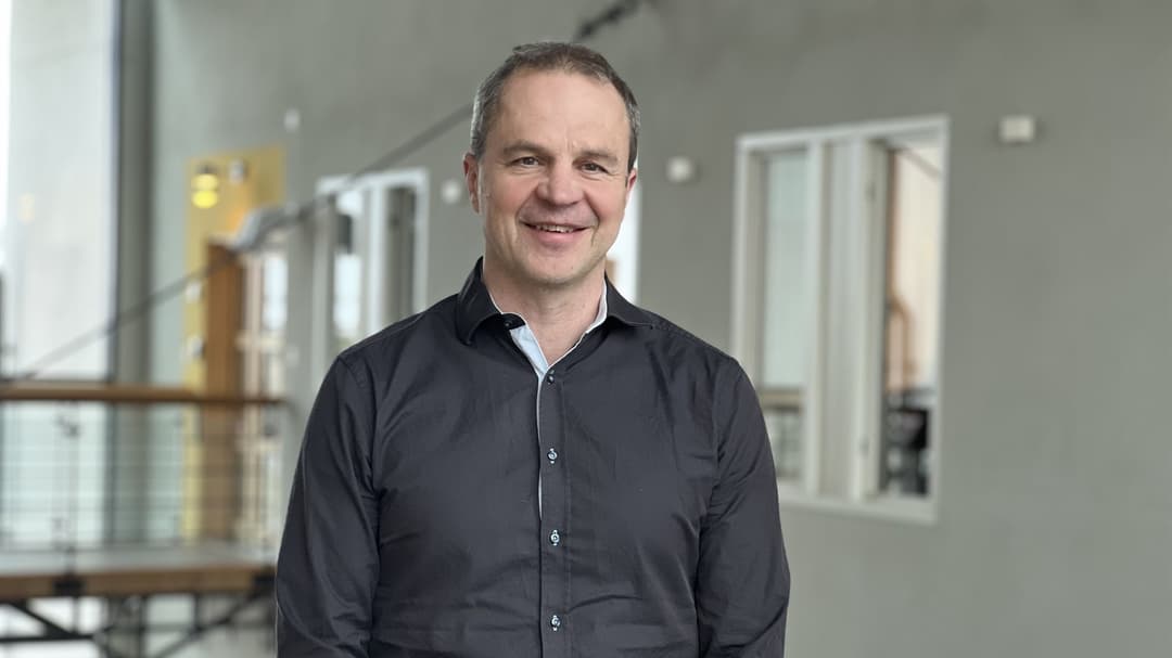 A man smiles and looks into the camera.