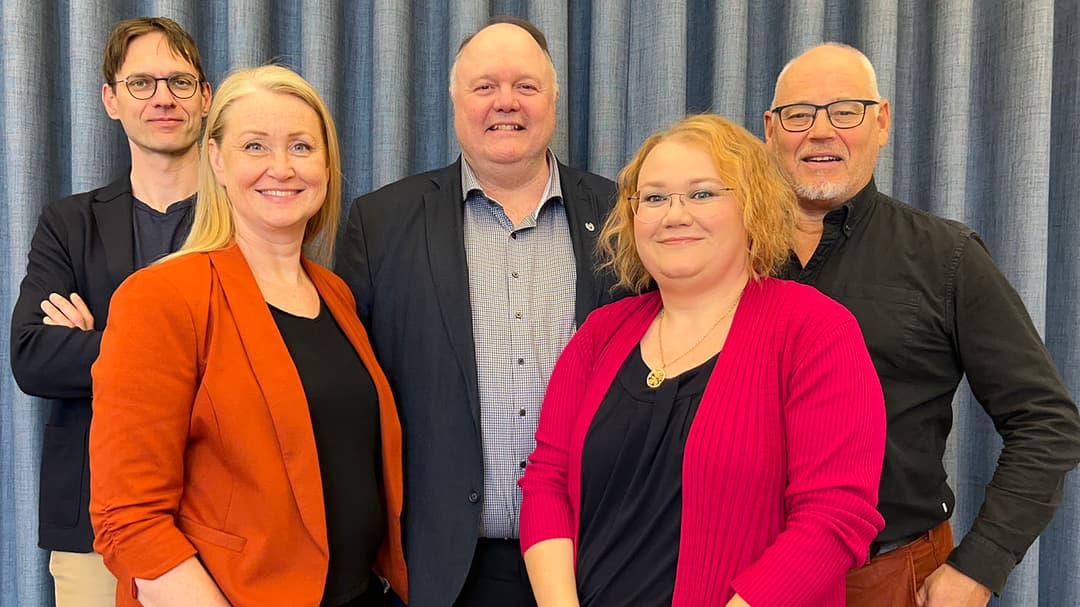 Fem personer, två kvinnor och tre män står uppställda för gruppfoto.