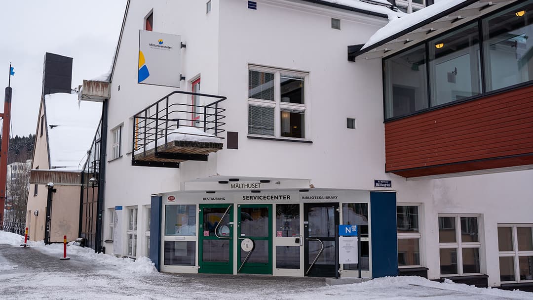 En vit byggnad med entré och balkong