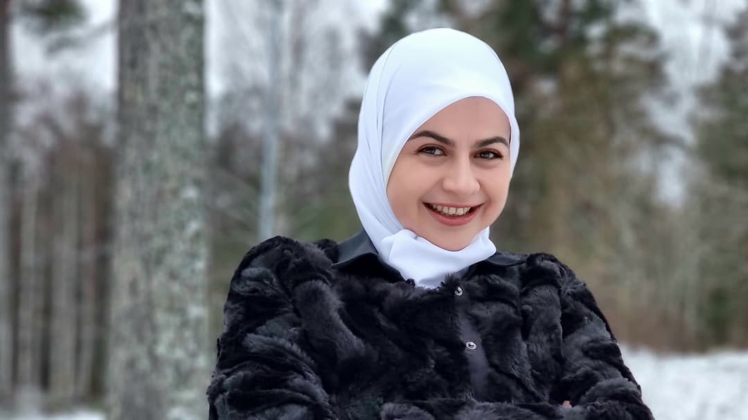 En ung leende kvinna i en skog 