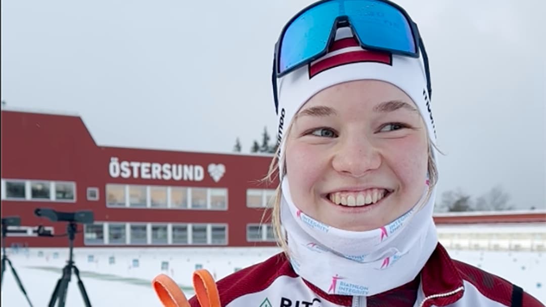 Smiling woman at a biathlon stadion.