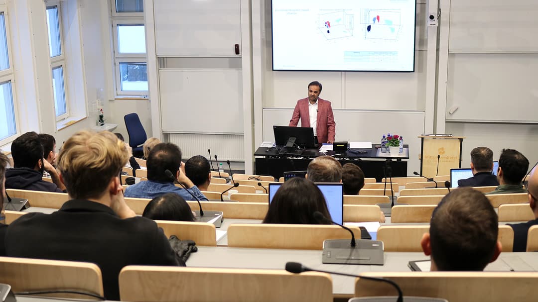 En man står och föreläser i en gradängsal.