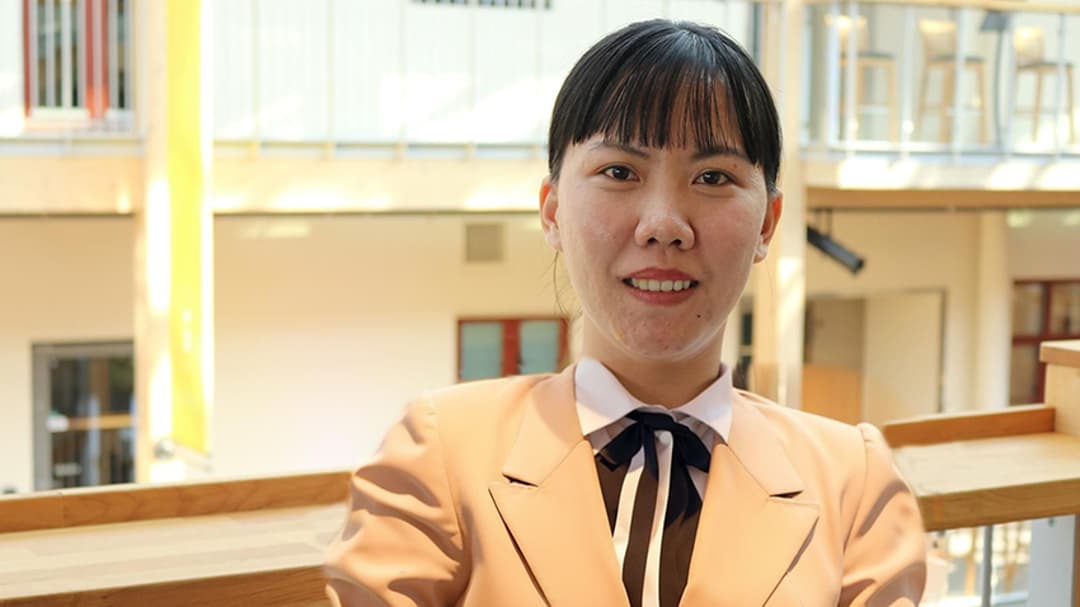 Asiatisk kvinna poserar framför kameran.