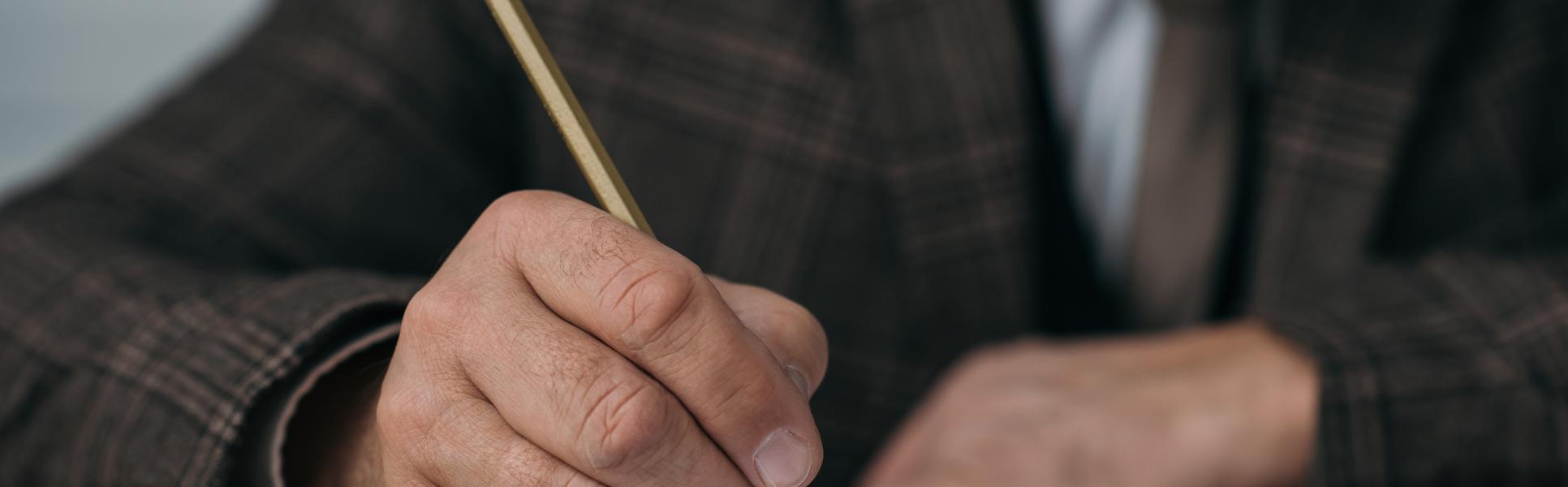 26573992-close-up-shot-of-senior-man-writing-in-notebook-with-pencil.jpg