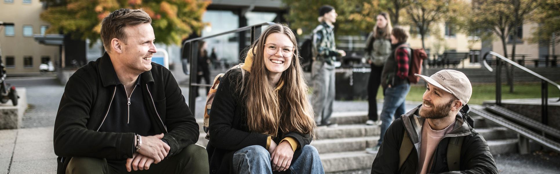 Tre studenter som sitter i en trappa utanför Campus Östersund