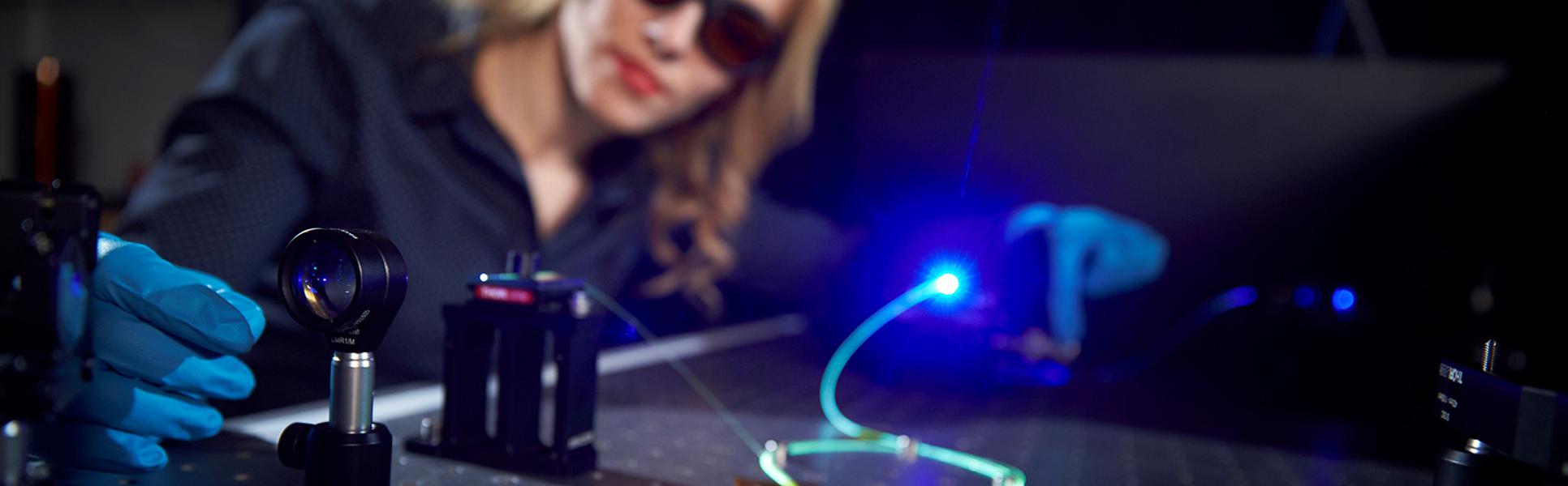 Enkeleda Balliu working with laser and fiber optic in the lab