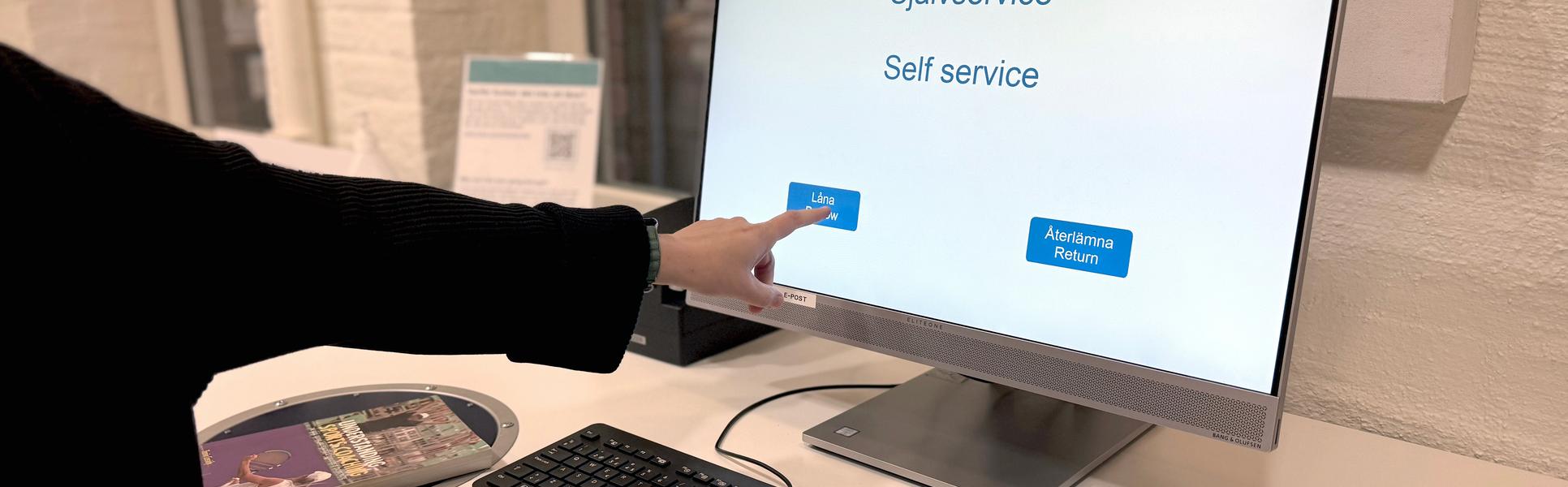 hand pekar på datorskärm