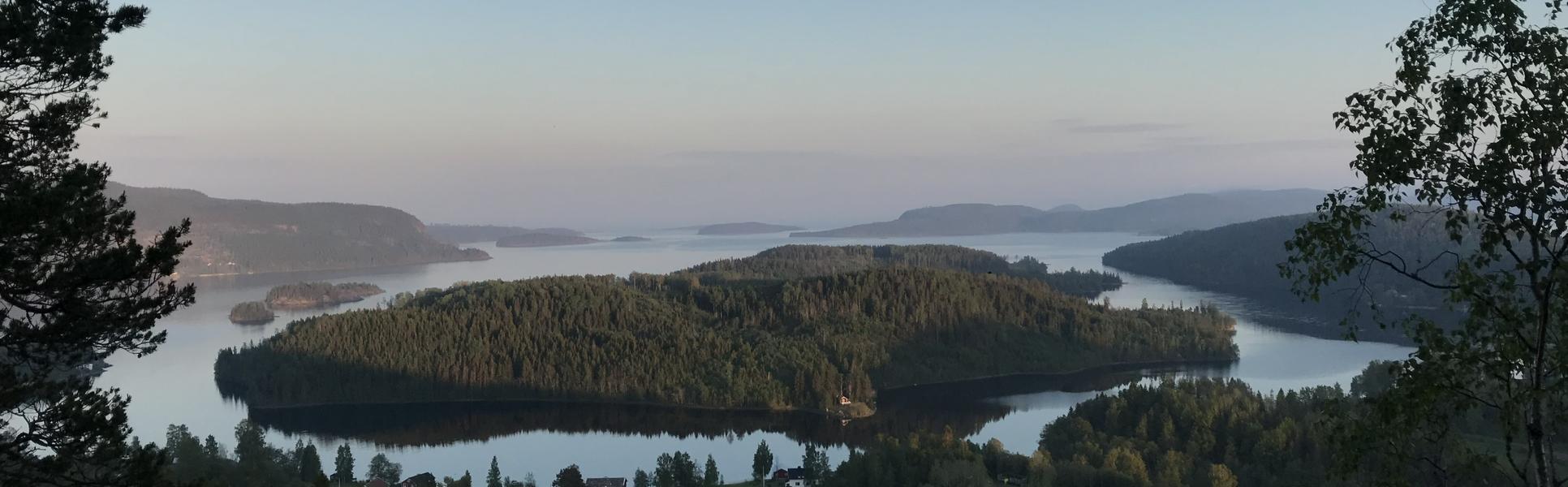 Utsikt över skogsklädda öar i stilla vatten.