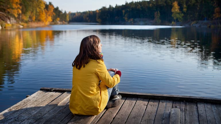 A woman sitting by the sea