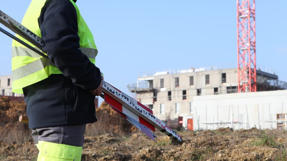 Builder in construction site near crane