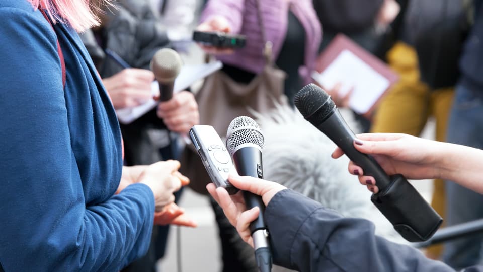 31454492-public-figure-talking-to-the-media-journalists-holding.jpg