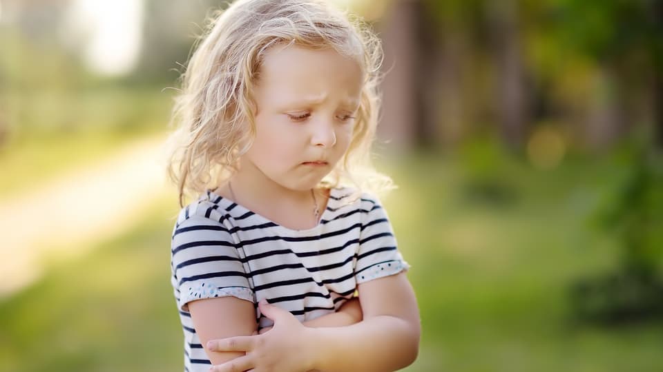 Upset or offended girl standing on the side of a road.