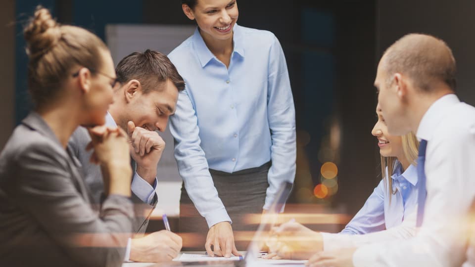 8476651-smiling-female-boss-talking-to-business-team.jpg