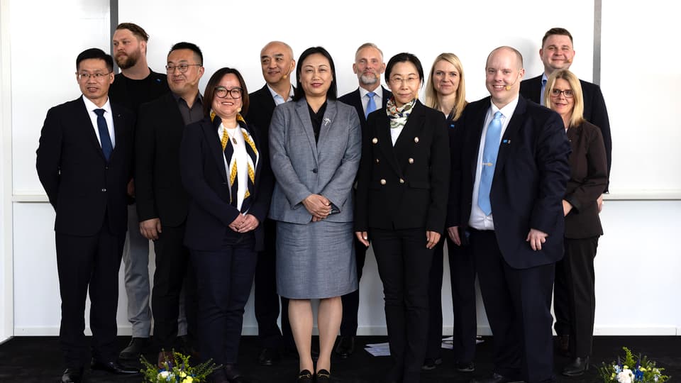 Group of men and women in front of white wall
