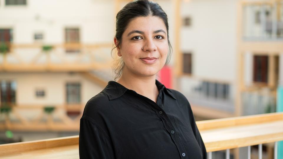 A woman in black, with her hair done up and wearing a black blouse. 