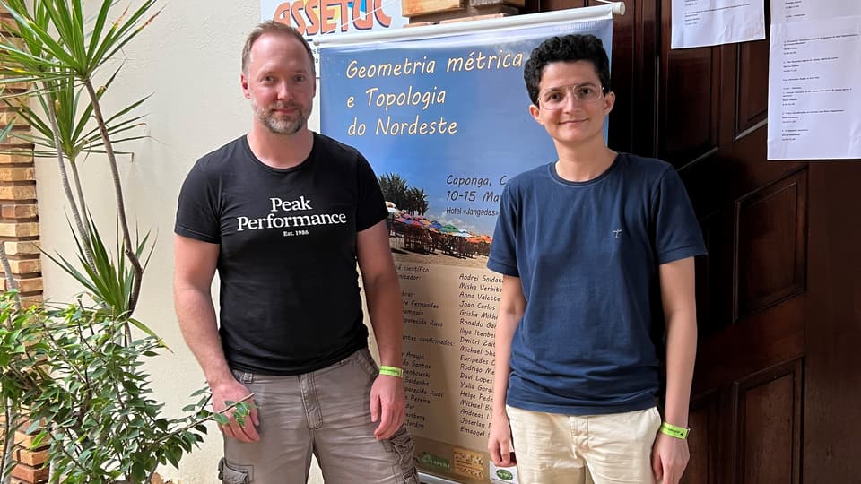  Two people are standing in front of a door.