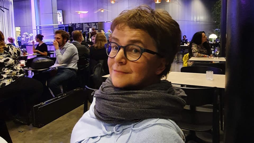 en kvinna med glasögon som sitter på en restaurang