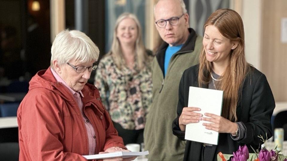 Two women, one older and one younger, stand opposite each other and talk. 