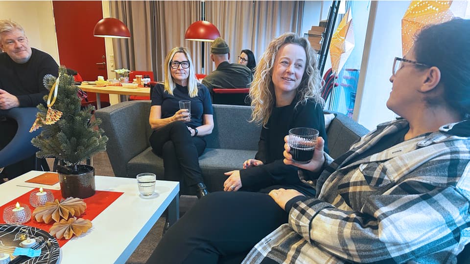 folk som sitter i en soffa och dricker kaffe