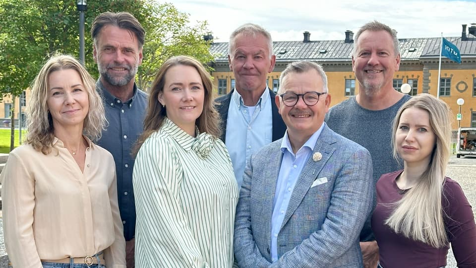 A group photo of seven people outdoors.