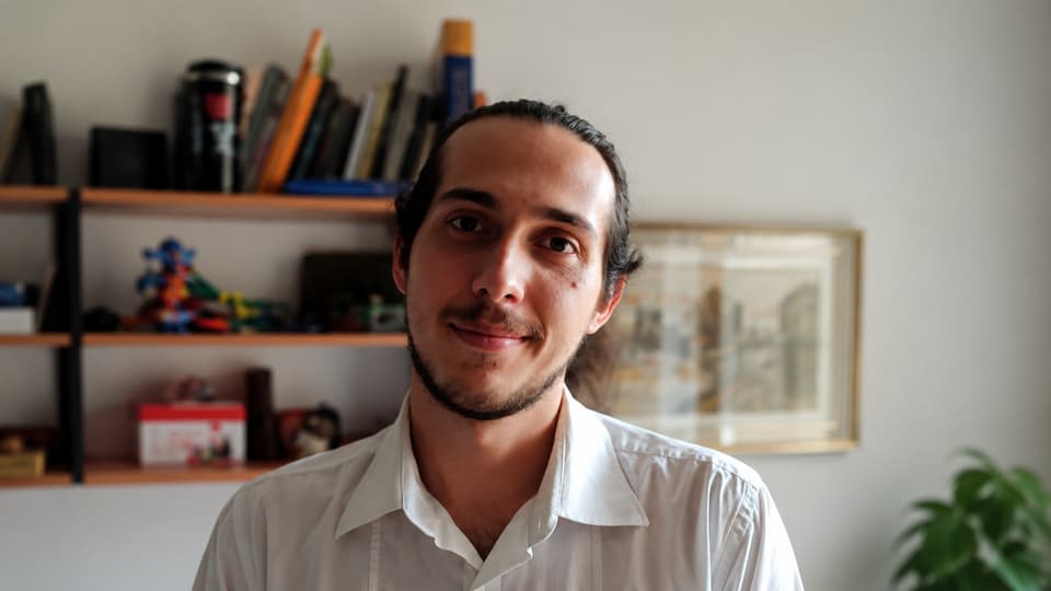 A man with black hair and a whiteshirt