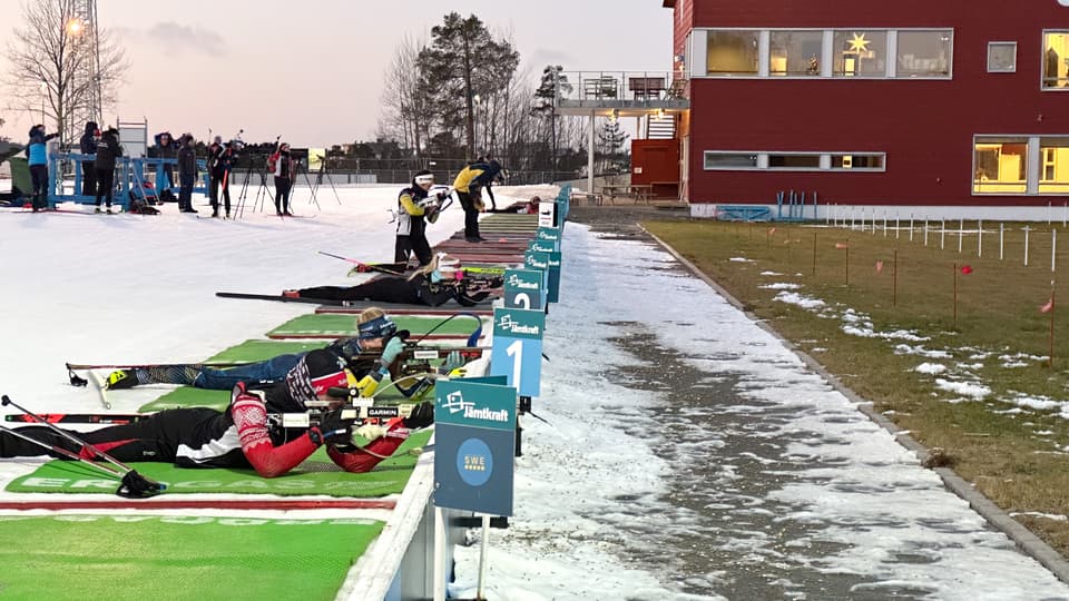 Skidskyttar övar liggande skytte på skjutvallen.