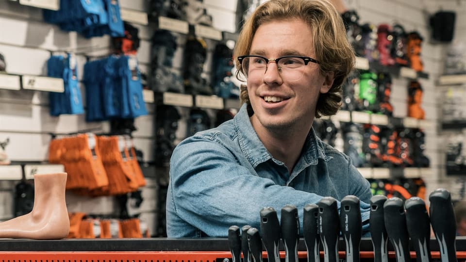 Kille i butiksmiljö med skidartiklar i bakgrunden