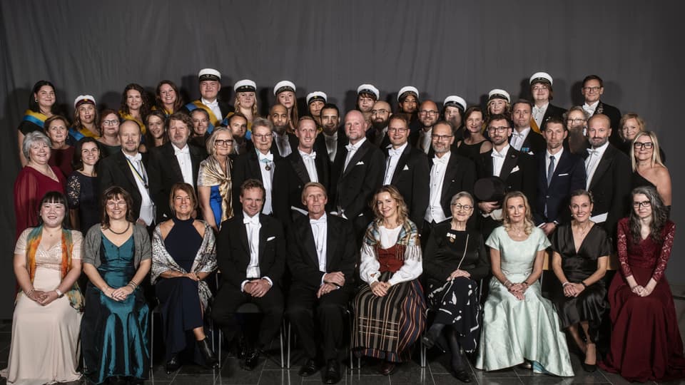 En gruppbild med drygt 50 finklädda personer. 