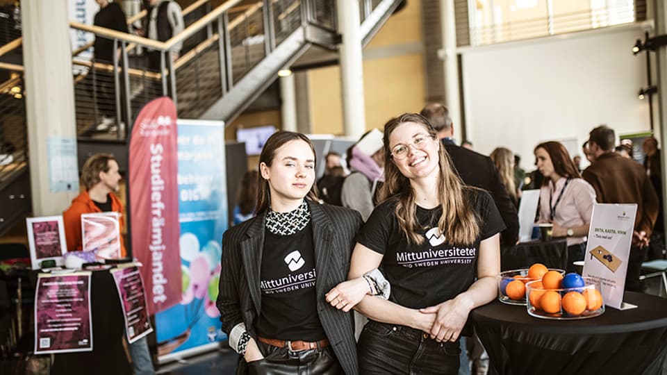 Two smiling student ambassadors at a fair in Ljushallen..