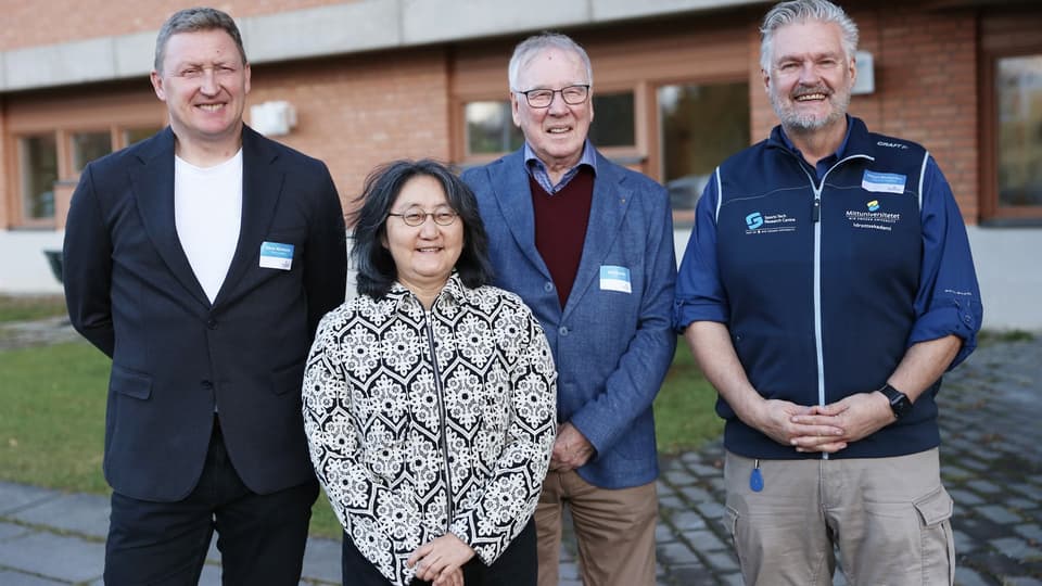 Group of smiling people in front of building.