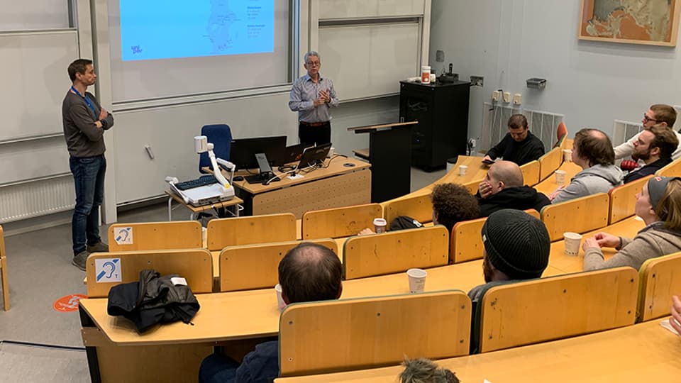Studenter sitter i en föreläsningssal och lyssnar på en gästföreläsning.