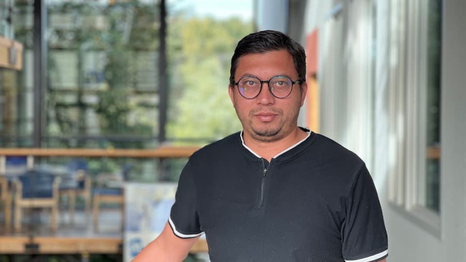 A man with glasses and a black shirt