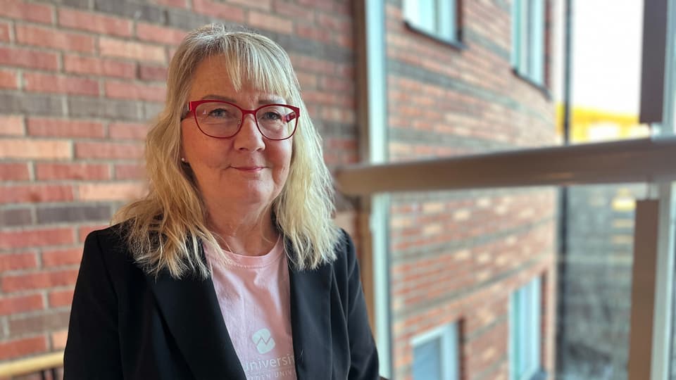 En kvinna står framför ett fönster