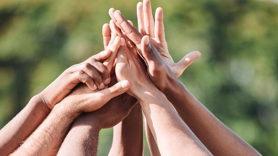 Multiple hands coming together in a high five