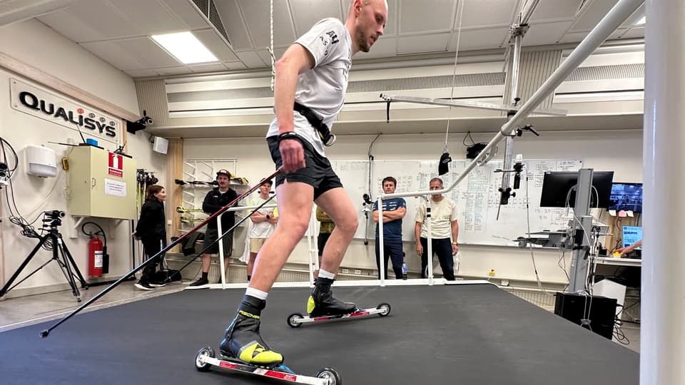 A man is roller-skiing on a treadmill.