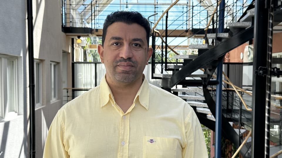 A man with black hair and a yellow shirt