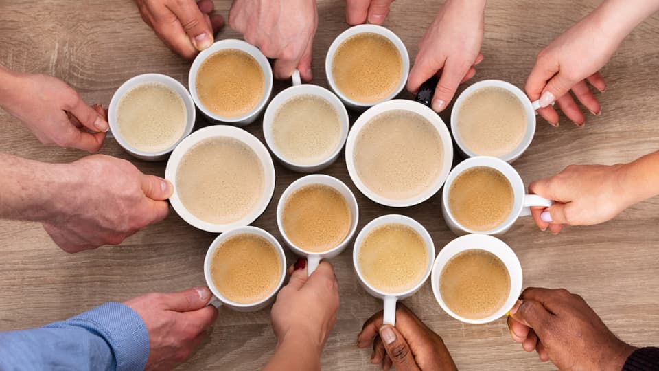 A group of people holding coffee cups